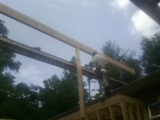 Carpenter setting a ridge beam over a new addition frame — Ice Dam Removal by Roofing Brothers in Taunton