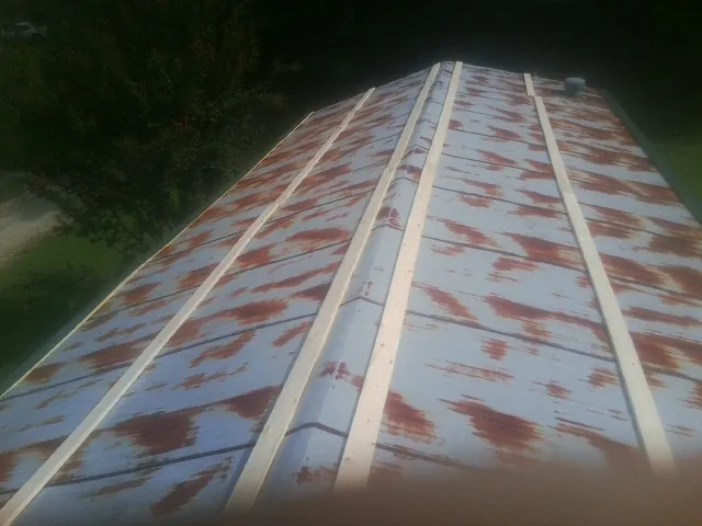 Rusted metal roof panels with new wood purlins before replacement — Storm Damage Roof Repair in Taunton by Roofing Brothers