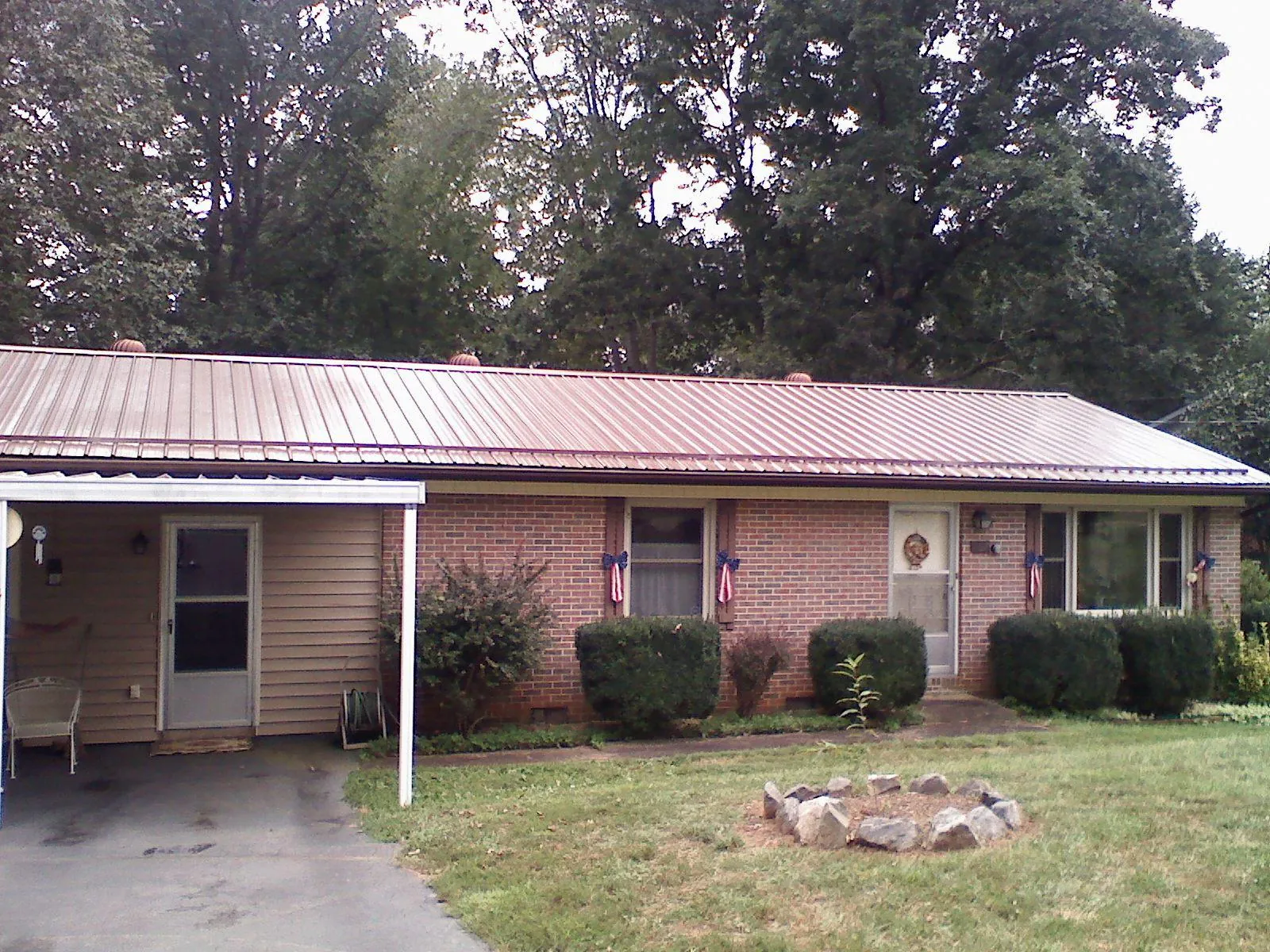 Bronze metal roof and carport on a brick ranch home — Roof Repair work by our crew in Taunton